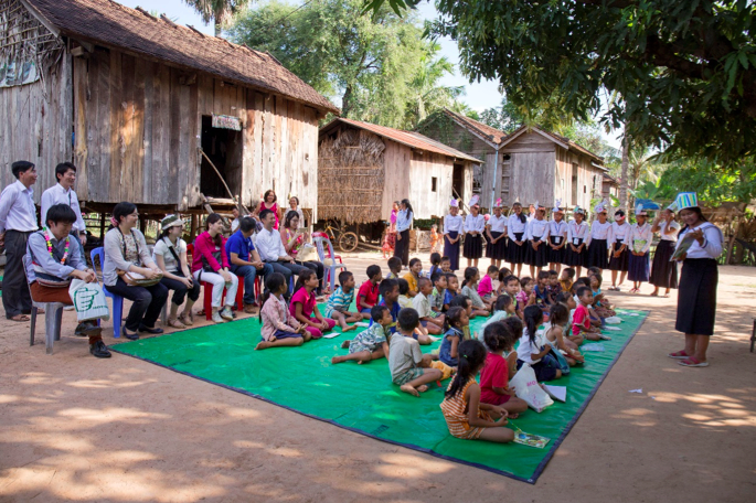 アビームが支援する女子教育プログラムの生徒たちが、村の子ども達にボランティアで読み聞かせをするところ